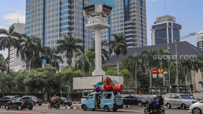 Suasana arus lalu lintas disekitat Tugu Jam Thamrin  di Jl. MH. Thamrin, Jakarta Pusat, Minggu (8/11). [Suara.com/Alfian Winanto]