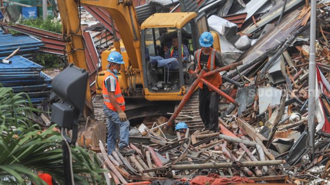 Pekerja menyelesaikan proyek renovasi gedung Sarinah  di Jalan MH. Thamrin, Jakarta Pusat, Minggu (8/11). [Suara.com/Alfian Winanto]