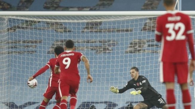 Pemain Liverpool Mohamed Salah (kiri) mencetak gol dari tendangan penalti ke gawang Manchester City dalam lanjutan Liga Inggris di Etihad Stadium .Clive Brunskill / POOL / AFP