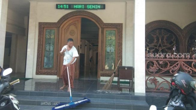 Seorang Marbot sedang membersihkan Masjid Nurul Iman, Selapajang, Kota Tangerang, untuk persiapan rombongan FPI dan jamaah 212 bermalam dalam rangka menjemput Habib Rizieq Shihab, Senin (9/11/2020). [Suara.com/Ridsha Vimanda Nasution]