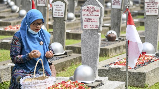 Seorang warga berdoa di depan pusara Presiden RI ke-3 B.J. Habibie saat Upacara Ziarah Nasional di Taman Makam Pahlawan Nasional Utama (TMPU) Kalibata, Jakarta, Selasa (10/11/2020). [ANTARA FOTO/M Risyal Hidayat]