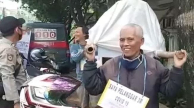 Tangkapan layar video warga dihukum menggotong keranda mayat karena kedapatan tak memakai masker dalam Operasi Yustisi di Jalan Raya Pangkalan Jati, Cinere, Kota Depok. [Instagram]