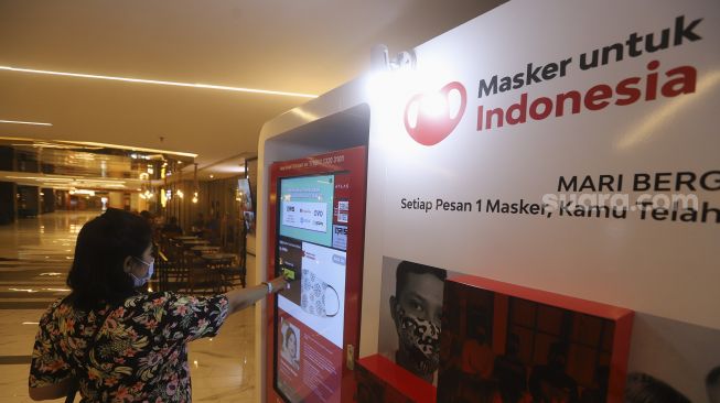 Pengunjung memilih masker yang dijual pada "vending machine" di Senayan City Mall, Jakarta, Rabu (11/11/2020). [Suara.com/Angga Budhiyanto]