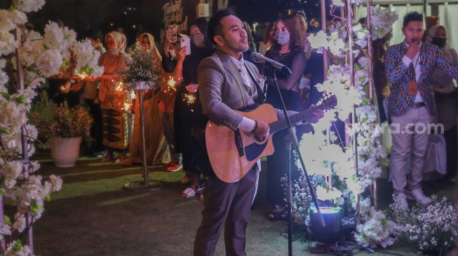 Danu Sofwan bernyanyi untuk istrinya, Jenita Janet saat resepsi pernikahan mereka di Green Forest Resort, Bandung, Jawa Barat, Rabu (11/11). [Suara.com/Alfian Winanto]