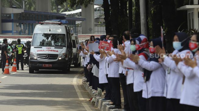 Sejumlah karyawan Kementerian Kesehatan melakukan tepuk tangan secara bersama di depan Gedung Kementerian Kesehatan Republik Indonesia, Jakarta, Kamis (12/11/2020). [Suara.com/Angga Budhiyanto]