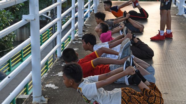 Sejumlah anak berolah raga di Jembatan Penyeberangan Orang (JPO) Kawasan Gunung Sahari, Jakarta, Rabu (11/11/2020).  [ANTARA FOTO/Wahyu Putro]