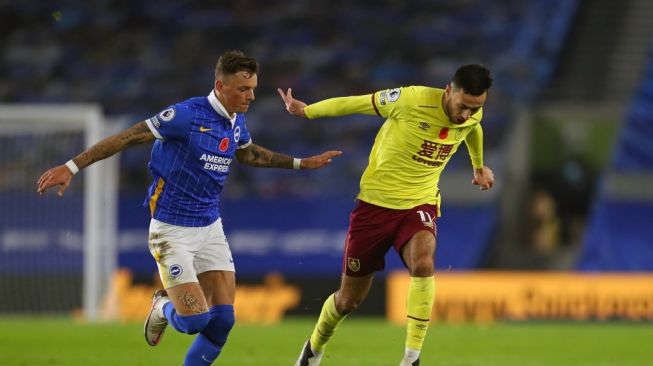 Bek tengah Brighton, Ben White (kiri) mengejar bola dari kaki pemain Burnley Dwight McNeil dalam laga lanjutan Liga Inggris di Express Community Stadium, Brighton, 6 November 2020. [Catherine Ivill / POOL / AFP]