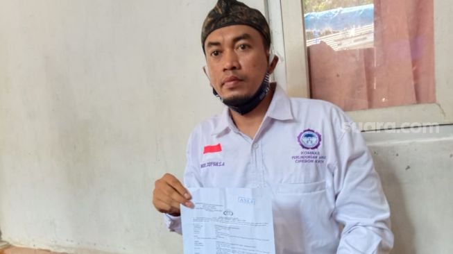 M. Sofyan, selaku Komnas Perlindungan Anak Cirebon Raya, saat memperlihatkan berkas laporan keluarga korban , Kamis (12/11/2020). [Suara.com/Abdul Rohman]