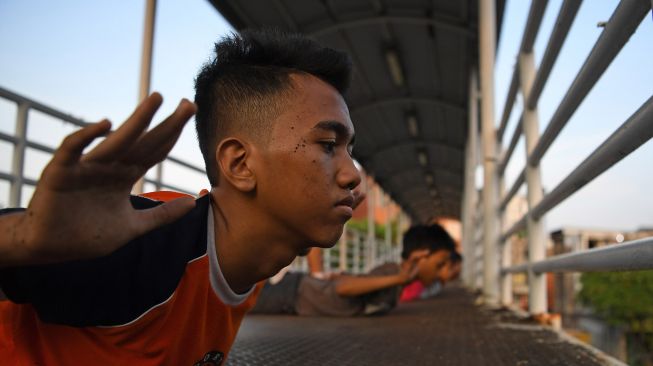 Sejumlah anak berolah raga di Jembatan Penyeberangan Orang (JPO) Kawasan Gunung Sahari, Jakarta, Rabu (11/11/2020).  [ANTARA FOTO/Wahyu Putro]