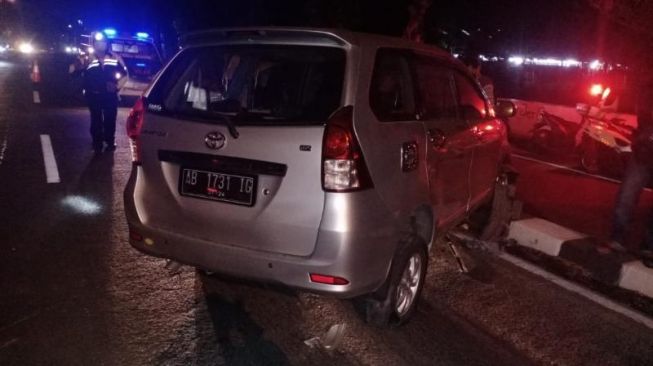 Mobil ringsek usai terlibat kecelakaan hingga melompati pembatas jalan di Ring Road Selatan (Jalan A Yani), Dusun Sarirejo, Desa Singosaren, Kecamatan Banguntapan, Kabupaten Bantul, Kamis (12/11/2020l) malam. - (SuaraJogja.id/HO-Polsek Banguntapan)