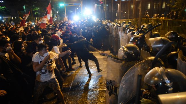 Demonstran bentrok dengan Polisi saat melakukan aksi terkait pemakzulan Presiden Martin Vizcarra di Lima, Peru, Kamis (12/11/2020).  [ERNESTO BENAVIDES / AFP]