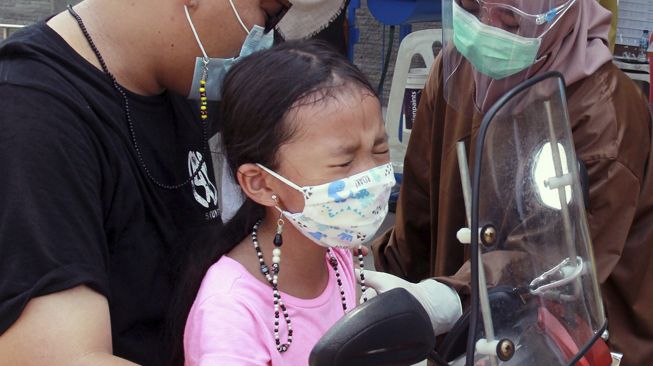 Petugas kesehatan puskesmas melakukan penyuntikan imunisasi Difteri Tetanus (DTTD) secara "Drive Thru", di Puskesmas Pondok Betung, Tangerang Selatan, Banten, Sabtu (14/11/2020). [ANTARA FOTO/Muhammad Iqbal]