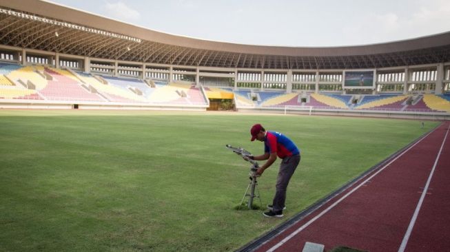  Pekerja mengecek mesin penyiram rumput di Kompleks Stadion Manahan, Solo, Jawa Tengah, Jumat (6/11/2020). Kementerian Pekerjaan Umum dan Perumahan Rakyat (PUPR) mulai melakukan renovasi empat lapangan pendukung untuk latihan dan Stadion Manahan yang akan menjadi venue utama pertandingan Piala Dunia U-20 tahun depan. ANTARA FOTO/Mohammad Ayudha/wsj. (ANTARA FOTO/MOHAMMAD AYUDHA)