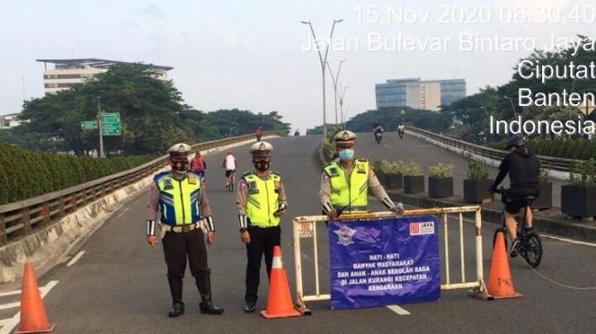 Sejumlah anggota polisi sedang mengamankan aktivitas olahraga sepeda di Jalan Boulevard Bintaro, Pondok Aren, Kota Tangerang Selatan, Minggu (15/11/2020) pagi. [Dok. Polisi]