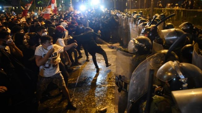 Demonstran bentrok dengan polisi saat melakukan aksi terkait pemakzulan Presiden Martin Vizcarra di Lima, Peru, Kamis (12/11/2020). Kongres Peru, Senin (9/11), memilih untuk melengserkan Presiden Martin Vizcarra dalam sidang pemakzulan atas tuduhan korupsi. Hasil sidang itu merupakan upaya kedua dalam beberapa bulan untuk menurunkan sang presiden dari kursi jabatannya atas tuduhan bahwa ia menerima suap sebagai gubernur dari perusahaan yang memenangkan kontrak pekerjaan umum. ERNESTO BENAVIDES / AFP