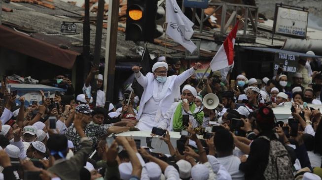 Imam Besar Front Pembela Islam (FPI) Habib Rizieq Shihab tiba di markas Front Pembela Islam, Petamburan, Jakarta, Selasa (10/11/2020). Habib Rizieq Shihab beserta keluarga kembali ke tanah air setelah berada di Arab Saudi selama 3,5 tahun. Saat tiba di markas Front Pembela Islam (FPI), Habib Rizieq Shihab disambut oleh massa dari sejumlah organisasi Islam dengan diiringi lantunan sholawat. [Suara.com/Angga Budhiyanto]
