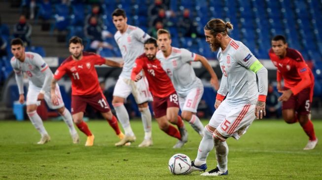 Pemain bertahan Timnas Spanyol Sergio Ramos ketika mengeksekusi penalti yang berujung gagal saat menghadapi Swiss di matchday kelima UEFA Nations League Divisi A Grup 4 (A4) di Stadion St. Jakob-Park, Basel, Swiss, Minggu (15/11/2020) dini hari WIB. [Fabrice COFFRINI / AFP]