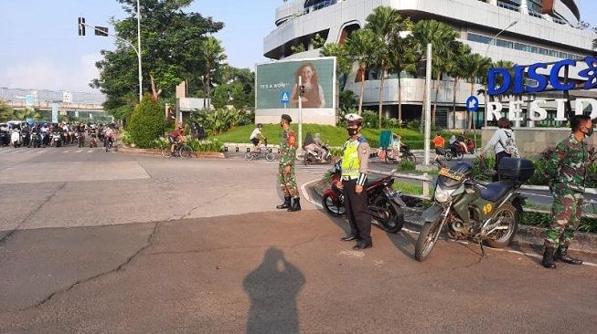 Petugas gabungan TNI-Polri sedang mengamankan aktivitas olahraga sepeda di Jalan Boulevard Bintaro, Pondok Aren, Kota Tangerang Selatan, Minggu (15/11/2020) pagi. [Dok. Polisi]