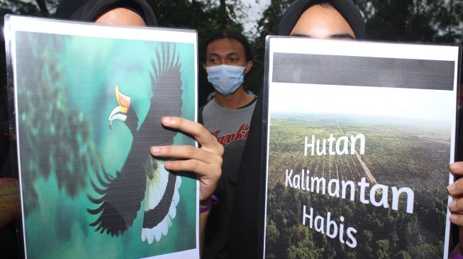 Dua mahasiswa Badan Eksekutif Mahasiswa (BEM) Sylva Fakultas Kehutanan Universitas Tanjungpura menggelar aksi selamatkan hutan Indonesia di Bundaran Digulis, Pontianak, Kalimantan Barat, Sabtu (14/11/2020). [ANTARA FOTO/Jessica Helena Wuysang]