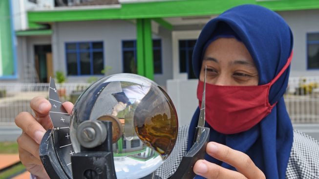 Petugas memeriksa alat ukur Intensitas Penyinaran Matahari (Campbell Stokes) di Laboratorium Terbuka Badan Meterologi, Klimatologi dan Geofisika (BMKG) Serang, Banten, Minggu (15/11/2020).  [ANTARA FOTO/Asep Fathulrahman]