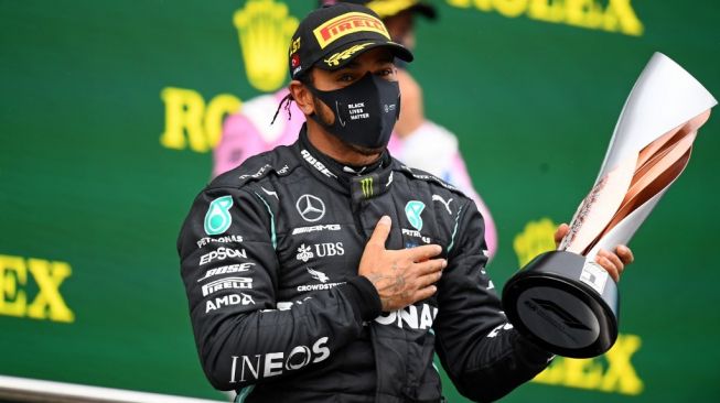 Pebalap Mercedes, Lewis Hamilton usai memenangi F1 GP Turki sekaligus menjadi juara dunia F1 2020, Minggu (15/11/2020) malam WIB. [Clive Mason / POOL / AFP]