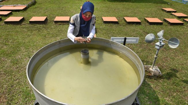 Petugas membaca skala ukur Panci Penguapan (Open Pan Evaporimeter) di Laboratorium Terbuka Badan Meterologi, Klimatologi dan Geofisika (BMKG) Serang, Banten, Minggu (15/11/2020). [ANTARA FOTO/Asep Fathulrahman]
