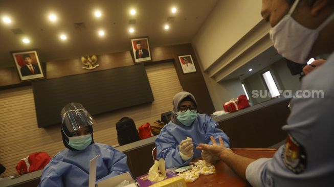 Petugas kesehatan melakukan tes cepat (rapid test) kepada anggota PPS dan PPK di Kantor Wali Kota Depok, Jawa Barat, Senin (16/11/2020). [Suara.com/Angga Budhiyanto] 