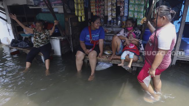 Sejumlah warga beraktivitas saat banjir rob menggenangi kawasan Sunda Kelapa, Jakarta, Selasa (17/11/2020). [Suara.com/Angga Budhiyanto]