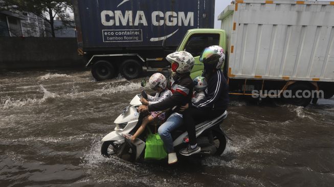 Pengendara sepeda motor melintasi banjir rob yang menggenangi kawasan Sunda Kelapa, Jakarta, Selasa (17/11/2020). [Suara.com/Angga Budhiyanto]