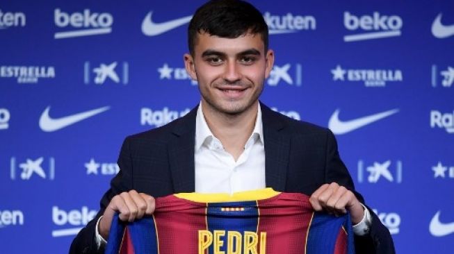 Pedri memegang jersey Barcelona saat diperkenalkan sebagai pemain baru di Camp Nou stadium pada 20 Agustus 2020. Josep LAGO / AFP