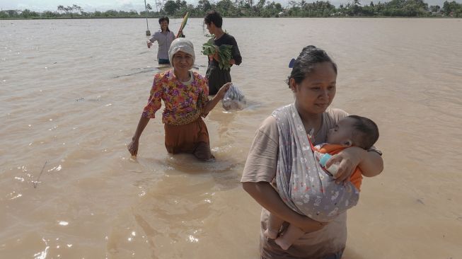 Sejumlah warga korban banjir meninggalkan lokasi pengungsian dan memilih kembali ke rumah karena khawatir dengan keselamatan harta benda mereka, di Desa Nusadadi, Sumpiuh, Banyumas, Jateng, Rabu (18/11/2020).  [ANTARA FOTO/Idhad Zakaria]