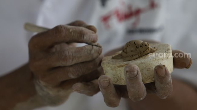 Pekerja menyelesaikan produksi keramik hias di Studio Workshop Rumah Keramik F Widayanto, Tanah Baru, Beji, Kota Depok, Jawa Barat, Rabu (18/11/2020). [Suara.com/Angga Budhiyanto]