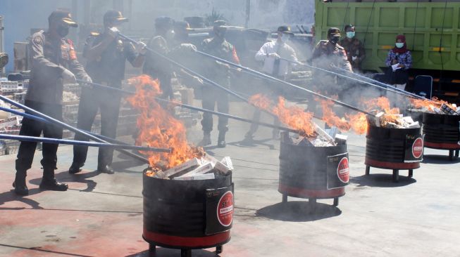 Sejumlah petugas memusnahkan barang bukti rokok ilegal di Kantor Pengawasan dan Pelayanan Bea dan Cukai (KPPBC) Tipe Madya Pabean Juanda, Sidoarjo, Jawa Timur, Rabu (18/11/2020). [ANTARA FOTO/Umarul Faruq]