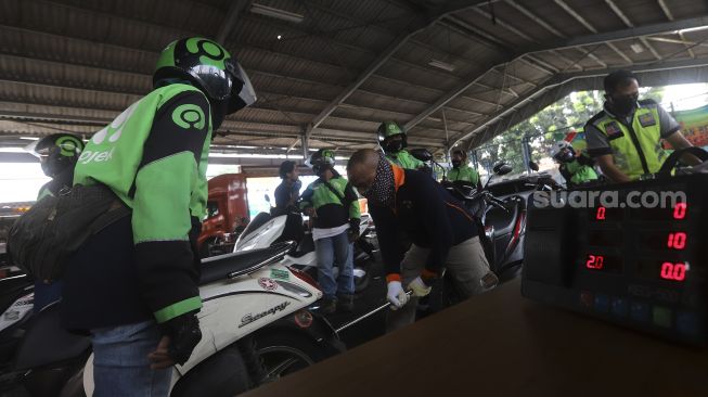 Pengemudi ojek online melakukan uji emisi kendaraan bermotor di Kantor Dinas Lingkungan Hidup DKI Jakarta, Kramat Jati, Jakarta, Kamis (19/11/2020). [Suara.com/Angga Budhiyanto]