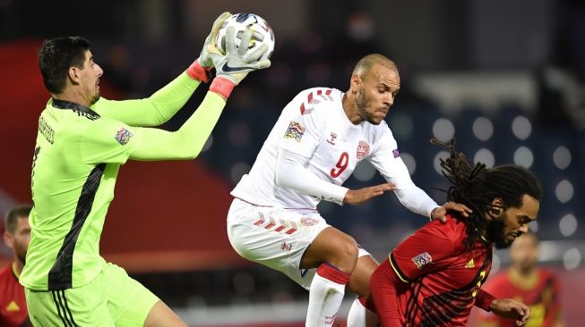 Kiper Timnas Belgia Thibaut Courtois (kiri) menangkap bola saat menghadapi Timnas Denmark di matchday keenam atau terakhir Divisi A Grup 2 (A2) UEFA Nations League, di King Power at Den Dreef, Belgia, Kamis (19/11/2020) dini hari WIB. [JOHN THYS / AFP]