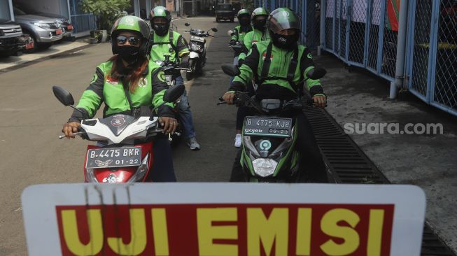 Sejumlah pengemudi ojek online mengantre untuk melakukan uji emisi kendaraan bermotor di Kantor Dinas Lingkungan Hidup DKI Jakarta, Kramat Jati, Jakarta, Kamis (19/11/2020). [Suara.com/Angga Budhiyanto]