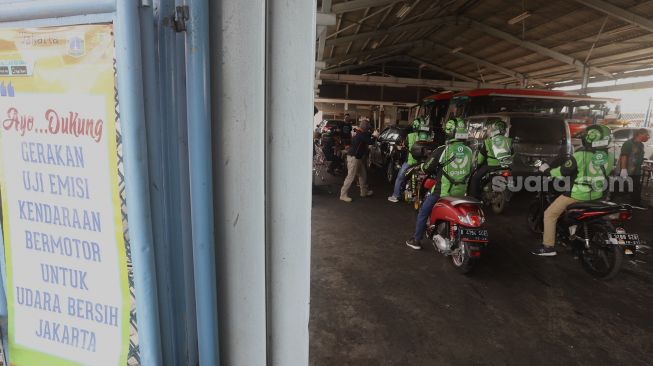 Sejumlah pengemudi ojek online mengantre untuk melakukan uji emisi kendaraan bermotor di Kantor Dinas Lingkungan Hidup DKI Jakarta, Kramat Jati, Jakarta, Kamis (19/11/2020). [Suara.com/Angga Budhiyanto]
