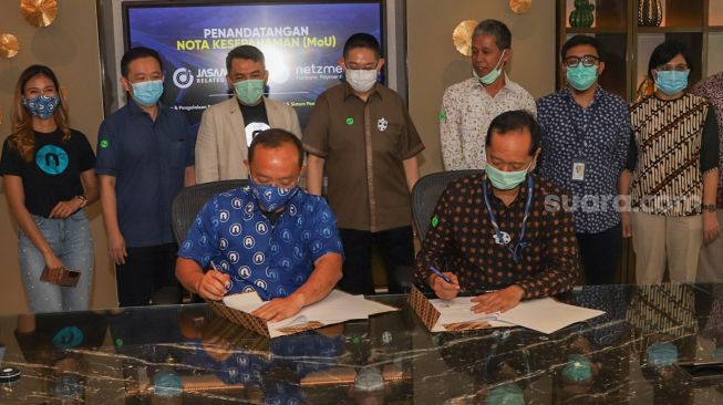 CEO PT Netzme Kreasi Indonesia, Vicky G. Saputra (kiri) dan Direktur Utama PT Jasa Marga Related Business, Cahyo Satrio Prakoso (kanan) saat proses penandatanganan Nota Kesepahaman (MoU) sebagai bentuk kerja sama di Kawasan Sudirman, Jakarta Pusat, Kamis (19/11). [Suara.com/Alfian Winanto]