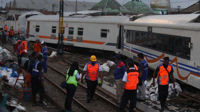 Sejumlah teknisi berusaha mengevakuasi rangkaian gerbong kereta api tak berlokomotif yang anjlok setelah sebelumnya meluncur tanpa kendali sejauh dua kilometer dan menabrak eskavator di Stasiun Kotalama, Malang, Jawa Timur, Rabu (18/11/2020).  [ANTARA FOTO/Ari Bowo Sucipto]