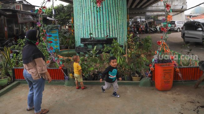 Anak - anak bermain di Taman Bermain yang ada di Kolong Jalan Layang Rawajati, Jakarta Selatan, Kamis (19/11). [Suara.com/Alfian Winanto]