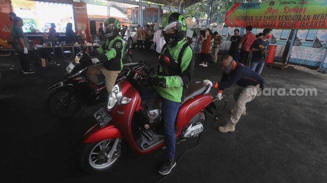 Pengemudi ojek online melakukan uji emisi kendaraan bermotor di Kantor Dinas Lingkungan Hidup DKI Jakarta, Kramat Jati, Jakarta, Kamis (19/11/2020). [Suara.com/Angga Budhiyanto]