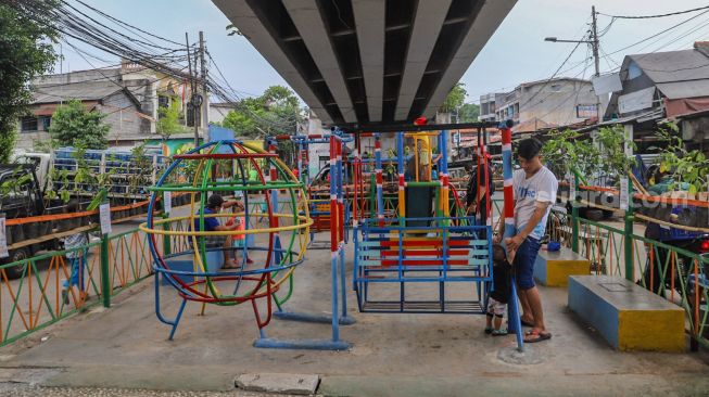 Suasana saat anak - anak bermain di Taman Bermain yang ada di Kolong Jalan Layang Rawajati, Jakarta Selatan, Kamis (19/11). [Suara.com/Alfian Winanto]