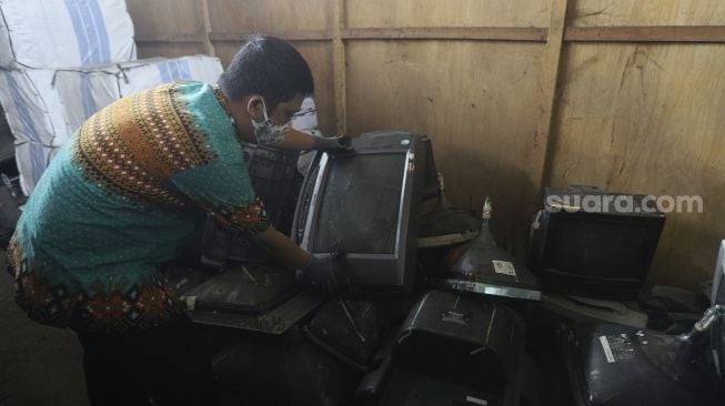 Petugas memeriksa limbah elektronik (e-waste) di gudang penyimpanan limbah e-waste dan limbah B3 Dinas Lingkungan Hidup DKI Jakarta, Kramat Jati, Jakarta, Kamis (19/11/2020). [Suara.com/Angga Budhiyanto]