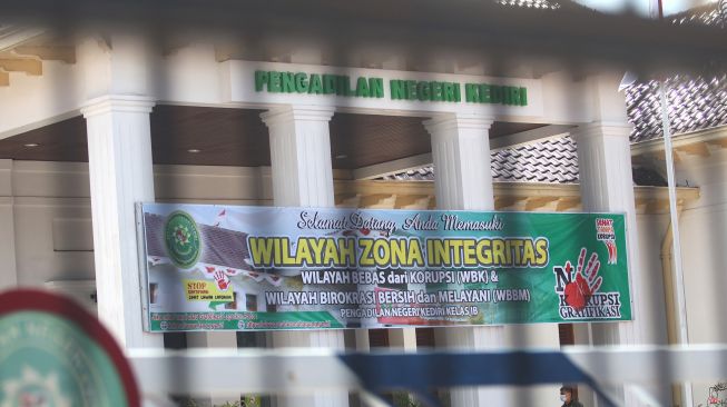 Seorang pegawai berjalan di dalam gedung Pengadilan Negeri Kediri Kelas 1B yang ditutup sementara di Kota Kediri, Jawa Timur, Kamis (19/11/2020).  [ANTARA FOTO/Prasetia Fauzani]