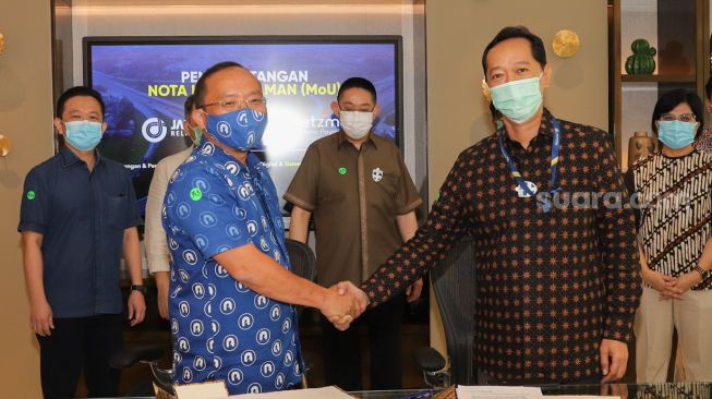 CEO PT Netzme Kreasi Indonesia, Vicky G. Saputra (kiri) dan Direktur Utama PT Jasa Marga Related Business, Cahyo Satrio Prakoso (kanan) saling berjabat tangan usai penandatanganan Nota Kesepahaman (MoU) sebagai bentuk kerja sama di Kawasan Sudirman, Jakarta Pusat, Kamis (19/11). [Suara.com/Alfian Winanto]