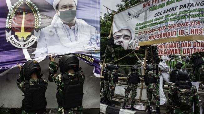 Prajurit TNI menurunkan spanduk bergambar Habib Rizieq Shihab saat patroli keamanan di Petamburan, Jakarta, Jumat (20/11/2020). [ANTARA FOTO/Aprillio Akbar]