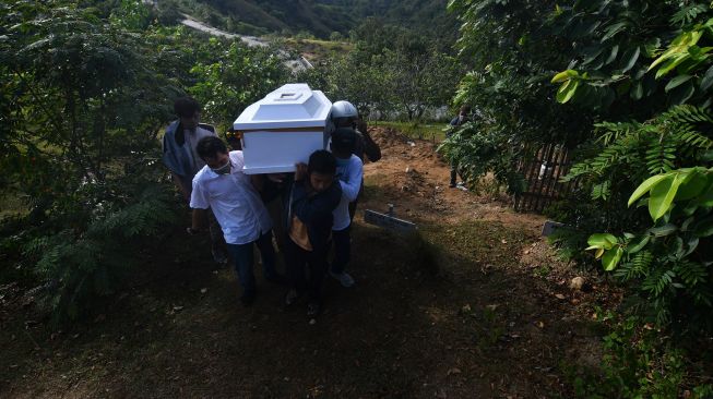 Pihak keluarga bersama Tim Pengacara Muslim (TPM) membawa peti berisi jasad terduga anggota kelompok teroris Mujahidin Indonesia Timur (MIT) Wahid alias Bojes di Pemakaman Umum Poboya, Palu, Sulawesi Tengah, Kamis (19/11/2020).  [ANTARA FOTO/Mohamad Hamzah]