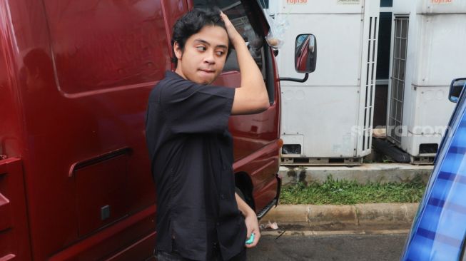 Bastian Steel mengaca didepan sebuah kendaraan saat ditemui awak media di Kawasan Tendean, Jakarta Selatan, Jumat (20/11). [Suara.com/Alfian Winanto]