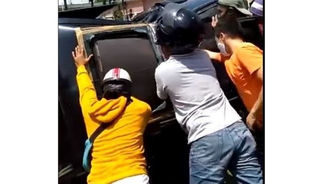 Mobil diangkat beberapa warga karena terguling setelah ditabrak moge Honda CBR1000RR (Facebook)