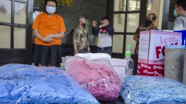 Tersangka beserta barang bukti sarung tangan medis bekas siap edar ditunjukkan saat rilis pengungkapan di Polrestabes Bandung, Bandung, Jawa Barat, Jumat (20/11/2020).   [ANTARA FOTO/Novrian Arbi]